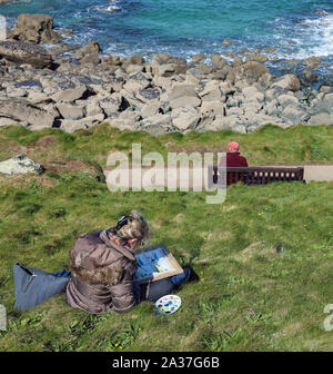 Ein Maler macht Bürste Skizzen von der Atlantikküste in St Ives Cornwall, Ihr belower eine einsame Gestalt auf einem Sitz sitzt Stockfoto