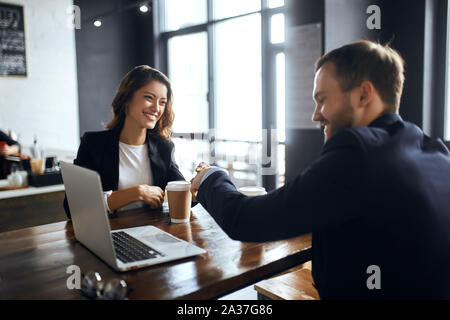 Fröhliche positive tatented Geschäftsleute über den Abschluss, die Unterzeichnung eines Vertrags während der Sitzung. Bis schließen Foto Stockfoto