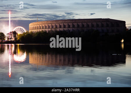 NÜRNBERG - Hitlers NSDAP Congress Hall bei Nacht beleuchtet von den angrenzenden Vergnügungspark. Stockfoto