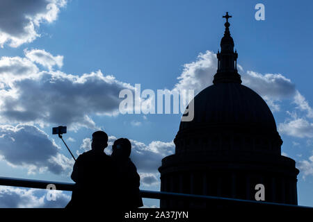 Touristen nehmen eine selfie mit einem selfie Stick von St Paul's Cathedral und die Skyline von London Stockfoto