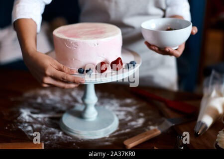 Junge Frau in Schürze lernen Kuchen vorzubereiten. Nahaufnahme 7/8 Foto. Stockfoto