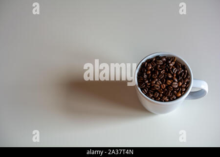 Weiße Tasse mit Kaffeebohnen gefüllt, Kopieren zur Verfügung Stockfoto