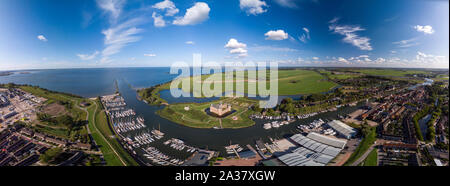 Breite Antenne Panoramablick auf das Schloss Muiderslot in Bergen in der Nähe von Amsterdams und seiner üppigen Gärten am IJsselmeer mit umliegenden Verankerung Stockfoto