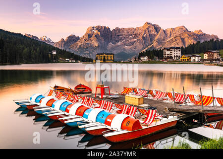 Schönen Sonnenaufgang über den Lago Misurina mit bunten Boote und glühenden Bergspitzen Reflexion. Stockfoto