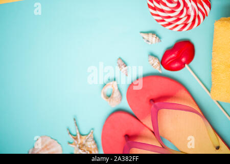 Helle Flip Flops mit Muscheln und roten Lutscher in Form der Lippen auf Minze Hintergrund. Flach Komposition. Strand, Sommer, Urlaub, Meer, Ferienhäuser co Stockfoto