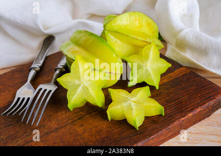 Exotischen starfruit oder averrhoa carambola auf Holz geschnitten. Gesunde Ernährung, frische organische star Apfel Obst. Carambolas Hintergrund Stockfoto