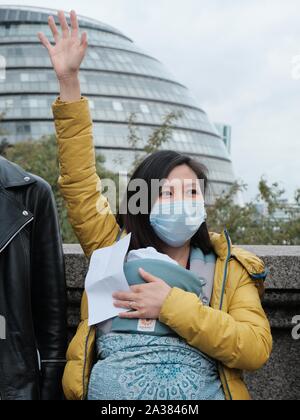 London, Vereinigtes Königreich. 5. Oktober, 2019. Chinesische Dissidenten Künstler Badiucao verbindet Hongkong pro-demokratischen Anhänger in eine Menschenkette entlang der Tower Bridge. Credit: Siu K Lo/Alamy News Live Stockfoto