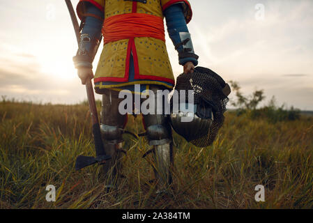 Mittelalterliche Ritter in Rüstung hält Ax und Helm. Stockfoto