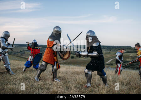 Ritter in Rüstung und Helm Kampf mit Schwertern Stockfoto