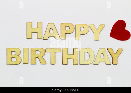 Happy birthday mit Holz Buchstaben auf weiße Oberfläche und roten Herzen geschrieben Stockfoto