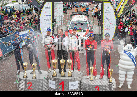 Llandudno, Wales, UK. 6. Okt 2019. Nicolas Gilsoul, Thierry Neuville, Martin Jarveoja, Ott Tanak, Sebastien Ogier, Julien Ingrassia feiern auf dem Podium des GB Welsh Rally 2019 Credit: Jason Richardson/Alamy leben Nachrichten Stockfoto