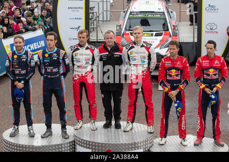 Llandudno, Wales, UK. 6. Okt 2019. Nicolas Gilsoul, Thierry Neuville, Martin Jarveoja, Ott Tanak, Sebastien Ogier, Julien Ingrassia feiern auf dem Podium des GB Welsh Rally 2019 Credit: Jason Richardson/Alamy leben Nachrichten Stockfoto