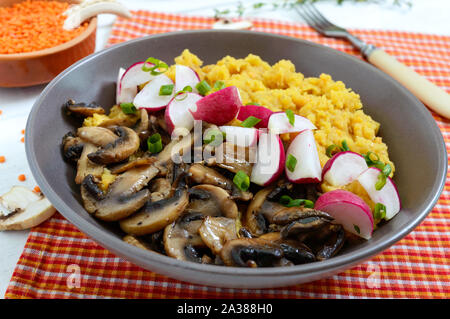 Linsen Porridge mit Champignons, Radieschen in einer Schüssel auf einem weißen Hintergrund. Diätetische, Lean Menü. Vegetarisches Gericht. Stockfoto