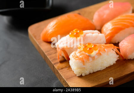 Ikura (roe) auf Lachs Garnelen Sushi und Sashimi Sushi auf Holz Platte, populäre Japanische Küche Stockfoto
