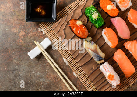 Nahaufnahme der sashimi Sushi mit Stäbchen und Shoyu Soße auf alten, braunen Stein, Japanisch essen einstellen Stockfoto