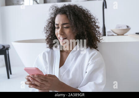 Frau verwechselt wird Ihr Smartphone Nachrichten lesen Stockfoto