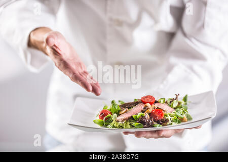 Koch in der Küche des Hotel oder Restaurant auf das Essen kurz vor dem Servieren. Stockfoto
