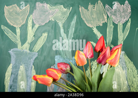 Live Blumen und Kinder Kreidezeichnung der Tulpen auf einer Tafel Stockfoto