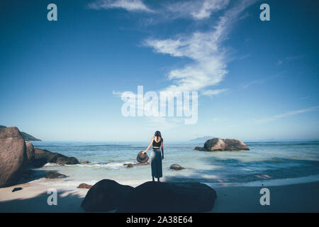 Frau am Strand mit einem Sonnenhut, Seychellen Stockfoto