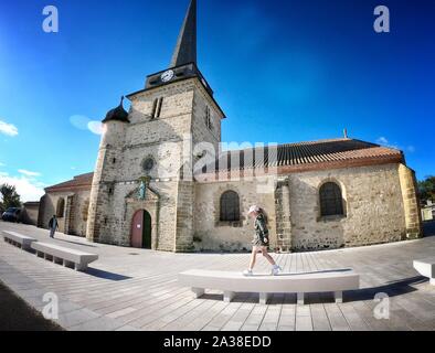 Mädchen zu Fuß auf einer Bank durch eine Kirche, Saint Jean de Monts, Vendee, Frankreich Stockfoto