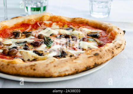 In der Nähe der traditionellen Capriciosa im italienischen Restaurant. Vorderansicht. Italienische Pizza Konzept Stockfoto