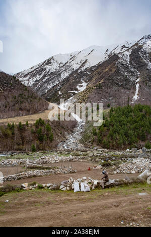 Menschen Reinigung Boden für den Anbau. Im Hintergrund Gletscherbach in Kinnaur Kailash, verbindet die Baspa River. Stockfoto