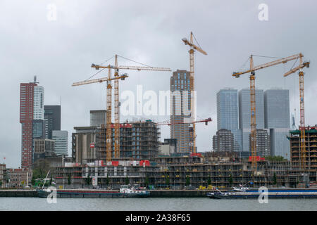 Die Skyline der Stadt mit Gebäuden an einem Fluss in Gewohnheit - durch Kräne in der niederländischen Stadt Rotterdam ed Stockfoto
