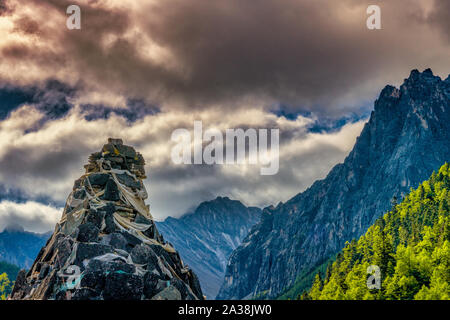 Gebirge gegen üppiges Grün und dramatische Wolken im Herbst in yading Naturschutzgebiet, China Stockfoto