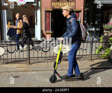 Krakau. Krakau. Polen. Junger Mann reiten electrik Scooter auf Grodzka Str. Zentrum der Altstadt. Stockfoto