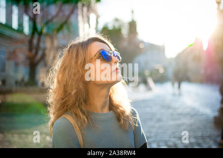 Seitenansicht der jungen Frau in Blau Sonnenbrille in den frühen Morgenstunden im alten Europäischen Stadt auf leeres Quadrat Stockfoto