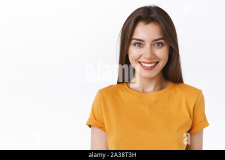 Close-up verlockend Glücklich lächelnde brünette Frau im gelben T-Shirt freuen Sie sich auf spannende Veranstaltung suchen, grinste freudig express Positivität und Stockfoto