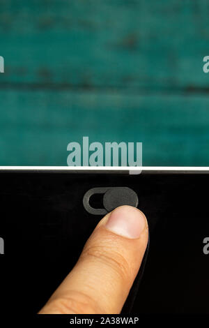 Kamera Datenschutz Schieben Sie mit einem Finger mit einem grünen Holz- wand. Stockfoto