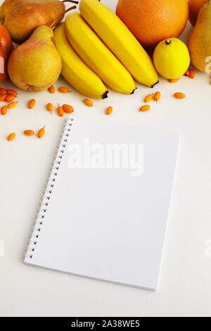 Frische Herbst gelb und orange Gemüse und Früchte und Notebook auf weißem Hintergrund, Ansicht von oben. Flach. Herbst Hintergrund. Stockfoto