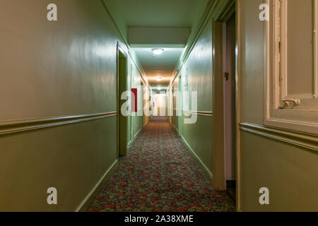 Lange dunkel und gruselig Flur in einem alten amerikanischen Apartment Gebäude Stockfoto