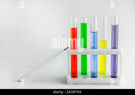 Röhrchen mit mehrfarbigen Reagenzien auf einem weißen Hintergrund. Chemie, Experimente Stockfoto