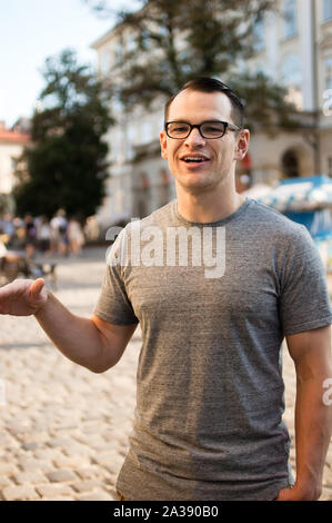 Im freien Portrait einer aufgeregt männliche Touristen auf der Straße mit Gebäuden einer alten Stadt in Europa in den Hintergrund Stockfoto