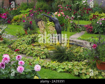 Chenies Manor Sunken Garden Zierteich mit Alan Biggs Skulptur in der Mitte mit Dahlie 'Creme de Cassis', 'Labyrinth' und verschiedenen Laub. Stockfoto