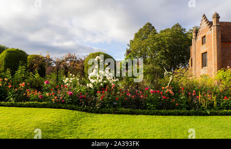 Letterbox Getreide der Chenies Manor Haus und Garten an einem schönen Abend Anfang September. Helle grüne Rasen, Dahlien, box Hedge- und Strauch rose.. Stockfoto