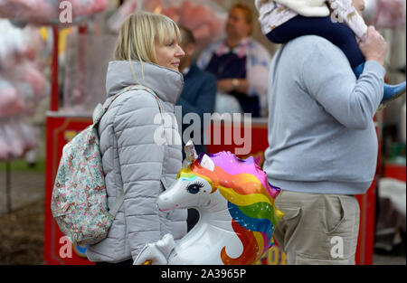 Blonde Dame mit Blow up Einhorn, an Goose Fair, Nottingham Stockfoto