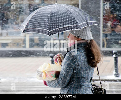 Belgrad, Serbien - 3. Januar 2019: Eine junge jugendmädchen alleine stehen unter dem Dach auf verschneiten Winter city street, warten, in Profil anzeigen Stockfoto