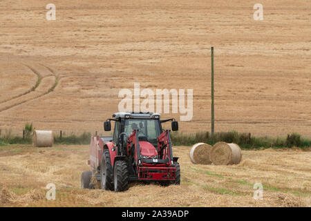 Pressen von Gerste Stroh auf Ackerland in Aberdeenshire Stockfoto