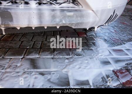 Ein Fragment der neuen weißen crossover Modell zum Zeitpunkt der Waschen mit Auto Shampoo. Stockfoto