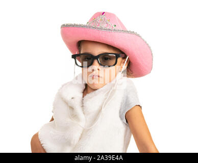 Junge Mädchen in Cowboy Hut und Sonnenbrille auf weißem Hintergrund posiert. Stockfoto