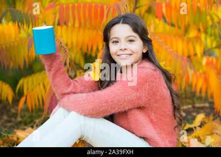 Jeden Morgen beginnt mit Kaffee. Glückliches Kind halten Tasse mit heißem Getränk auf Herbstmorgen. Kleines Mädchen trinken Kaffee oder Tee. Frühstück wakeup. Stockfoto