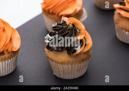 Köstliche Halloween Cupcakes mit schwarz und orange Creme Stockfoto