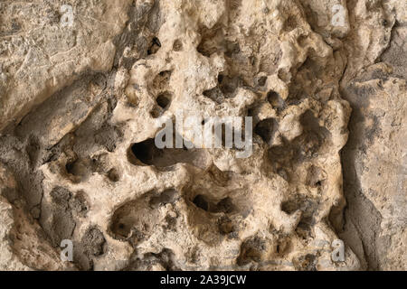 Nahaufnahme des rauen alten Stein, Relief Struktur, konkrete Struktur Wand. Unebene Oberfläche mit Noppen. Für moderne Hintergrund Stockfoto