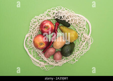 Blick von oben auf die Gemüse und Früchte in string Bag isoliert auf Grün Stockfoto