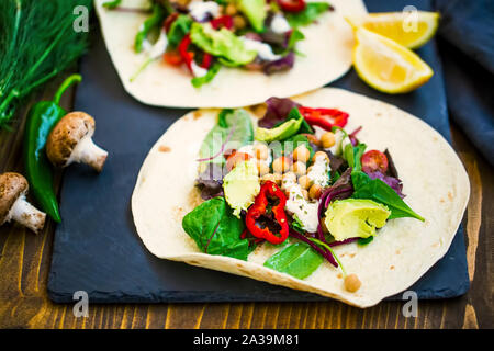 Vegan Wraps mit Salat, Kichererbsen, Gemüse und Avocado, gesunde Tortilla mit Gemüse gefüllt, vegetarisches Gericht Stockfoto