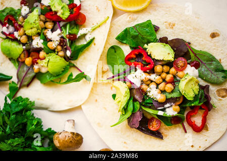 Vegan Wraps mit Salat, Kichererbsen, Gemüse und Avocado, gesunde Tortilla mit Gemüse gefüllt, vegetarisches Gericht Stockfoto