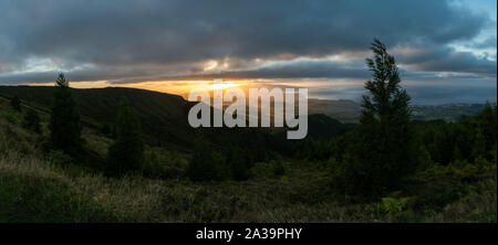 Atemberaubenden Sonnenuntergang Panorama der vulkanische Landschaft auf der Insel São Miguel auf den Azoren Archipel. Vulkankegel sind durch Sonnenstrahlen beleuchtet. Stockfoto